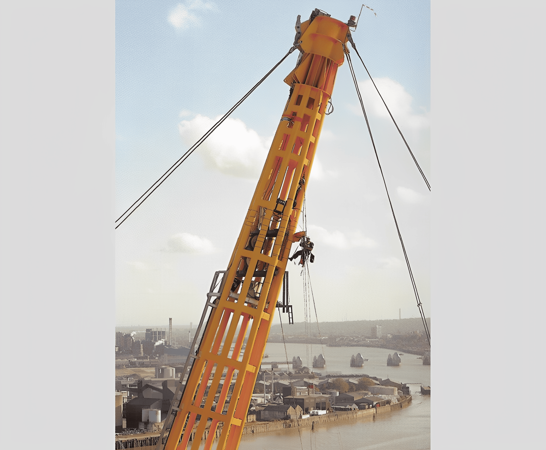 Worker climbing large yellow crane, city skyline.