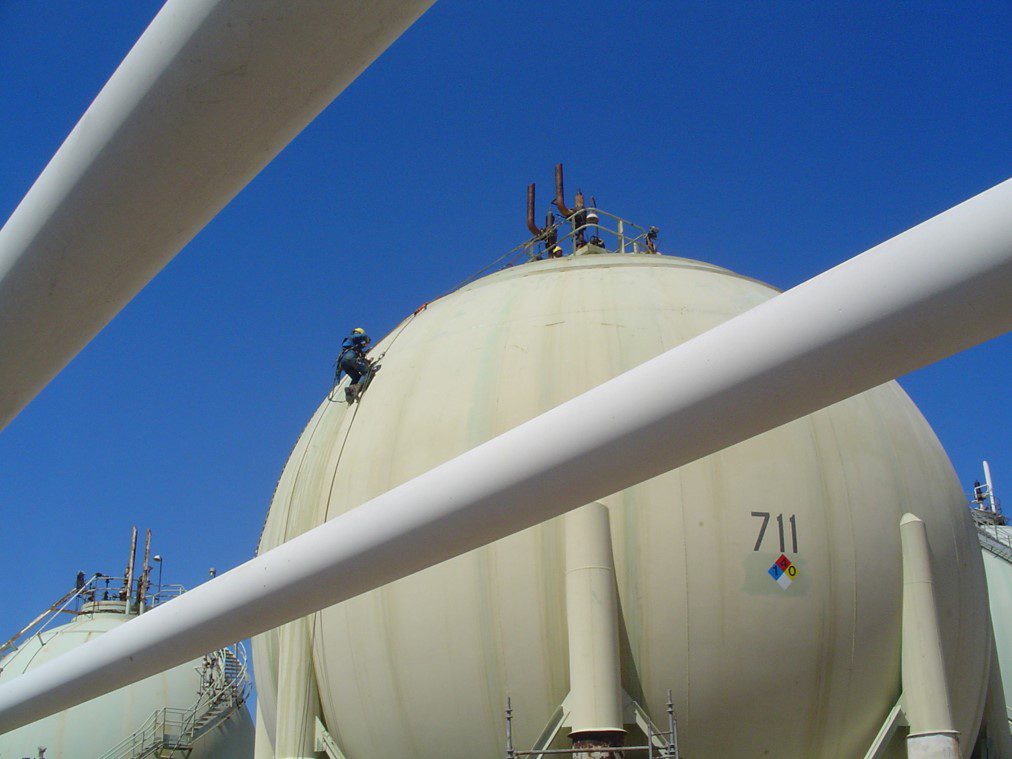 Workers on large industrial storage tank.